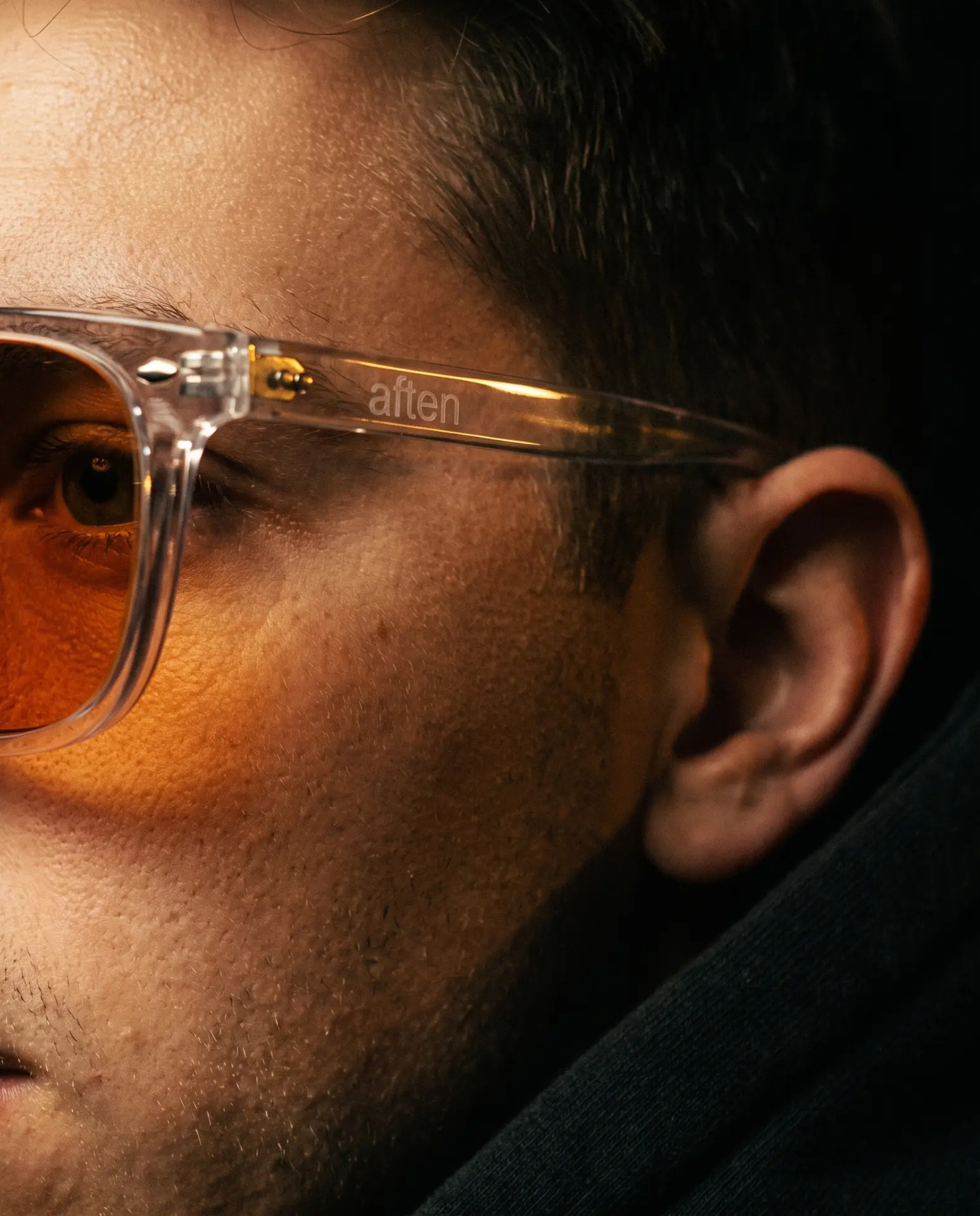 Close-up of the clear AFTEN frame and amber lens being worn