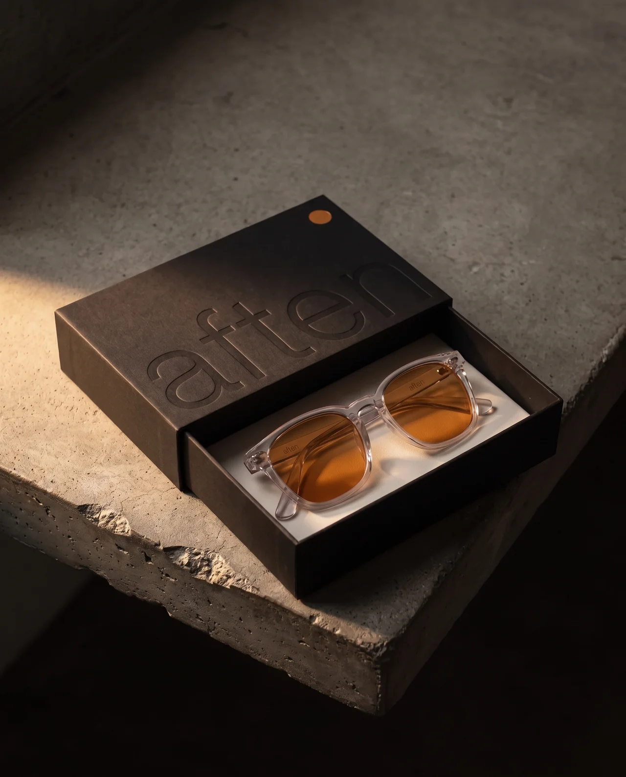 AFTEN One clear acetate glasses with amber lenses in their open black presentation box